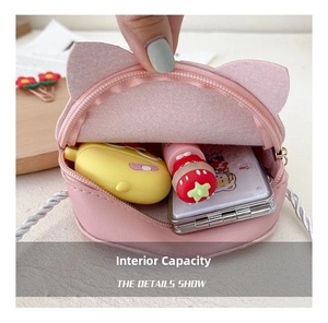 Pink cat crossbody bag interior detail showing space for lipstick and earphones