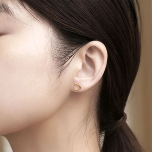 Sweet hollow heart stud earrings in gold finish for women on a fashion model