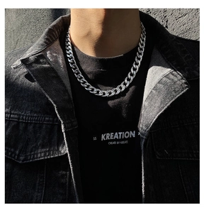 Gros plan d'un collier chaîne cubaine argentée épaisse sur un mannequin en look streetwear