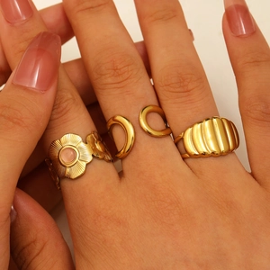 Detailed view of three-piece 18K gold plated stainless steel rings set on a model hand