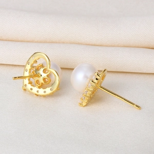Elegant S925 silver heart pearl earrings with sparkling zircons on a white silk background