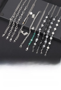 Detail view of titanium steel bracelets with black gallstone, faux pearls, and cross charms