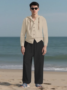 Detail of men's linen beach set featuring beige hooded shirt and black drawstring trousers