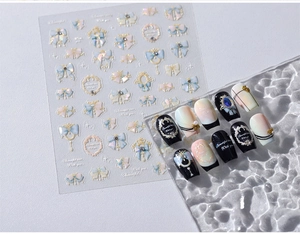 Détail de stickers ongles de Noël avec nœuds pastel et cadres dorés sur capsules