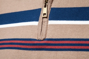 Detail of khaki men's sweater featuring color-block stripes and a bronze metal zipper