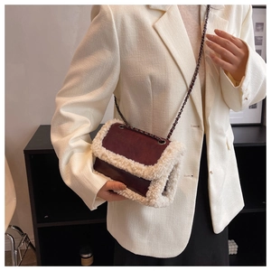 Close-up of retro burgundy chain bag with cream faux fur trim and matte leather finish