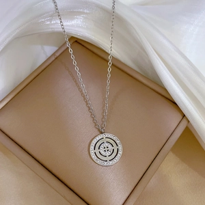 Macro shot of silver roman disk pendant necklace with sparkling inset crystals