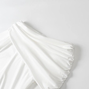 Detailed close-up of white ruched fabric texture on a modern elegant dress