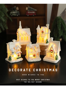 Set of five resin Christmas snow houses with warm LED lighting on dark background