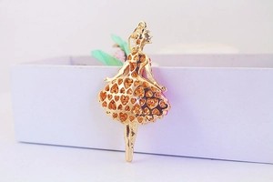 Close-up of golden ballet dancer charm showing the hollow heart design on the metal back