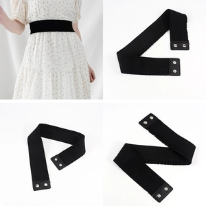 Detail view of women's black elastic waist belt with metallic double circle buckle and leather