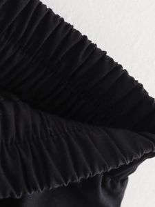 Vue macro détaillée de la taille élastique d'un pantalon noir en tissu texturé premium