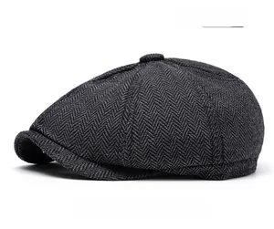 Detailed texture of dark gray herringbone newsboy cap with classic top button