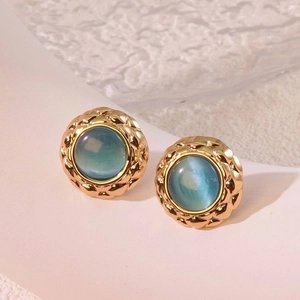 Detail of vintage round stud earring with quilted gold edge and turquoise stone inlay