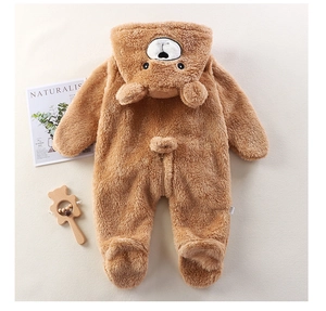 Détail d'une grenouillère bébé en peluche marron avec texture douce en polaire corail