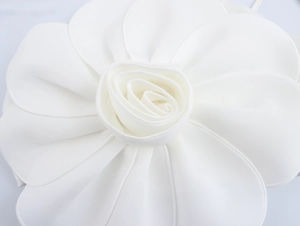 Detailed macro view of an elegant white fabric 3D flower decoration for a skirt set
