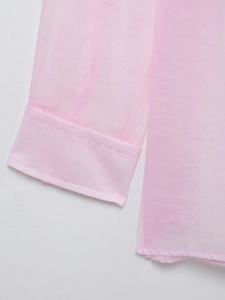 Dettaglio delle cuciture su polsini e orlo in tessuto di organza rosa semitrasparente