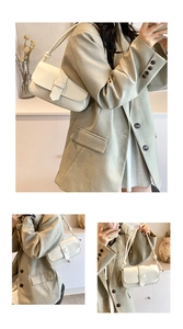 Close-up of a cream white leather underarm bag with a glossy finish and flap closure
