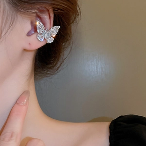Close-up of a delicate silver butterfly ear cuff with sparkling zircon stones for women