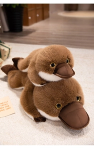 Close-up of two stacked platypus plush toys showing soft faux fur and glitter eyes