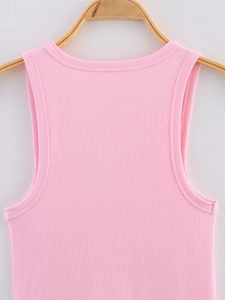 Close-up of pink sleeveless knit top showing ribbed texture on a wooden hanger