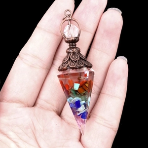 Pendentif d'énergie Orgone tenu à la main avec pierres naturelles et calotte en métal