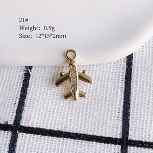 Macro detail of a 0.9g gold aircraft pendant with zircon inlays for DIY jewelry making