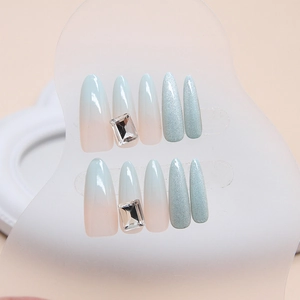 Cat eye press-on nails with mint green gradient, sparkling glitter, and luxury rhinestones
