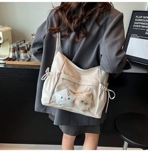 Creamy white tote bag with clear window showing plush star charms in a cafe setting
