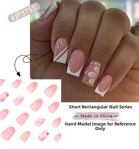 Macro detail of short square press-on nails with pink and white French floral patterns