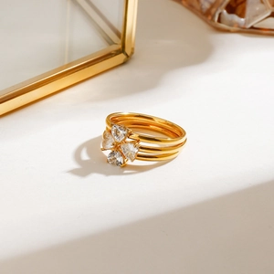 Close-up of gold layered ring with heart-shaped crystals on an elegant stand