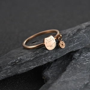 Roségoldener Winkekatze Ring mit Münzanhänger auf dunklem Steindisplay präsentiert
