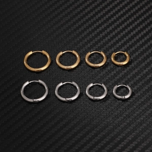 Detailed set of gold and silver hoop earrings in four sizes on a dark textured surface