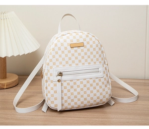 Close-up of white backpack with yellow floral pattern on a wooden desk with a lamp