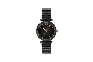 Detail of faceted prism glass lens on a black fashion quartz watch with rose gold indices