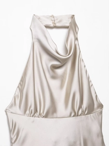 Detail of champagne satin halter top featuring a draped neckline and smooth silk texture