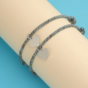Magnetic heart pendant bracelets with gray and blue braided ropes on a display stand