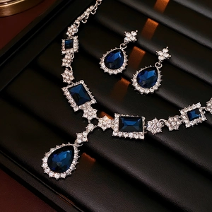Close-up of elegant jewelry set with blue pear-cut gems and sparkling diamond accents