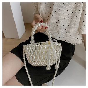 Détail du sac à main en perles avec nœud en satin et bandoulière tissée en perles