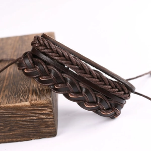 Close-up of brown multi-layer braided leather bracelet on a dark textured wood block