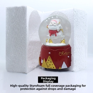 Close-up of Santa Claus and reindeer inside snow globe with Christmas base packaging