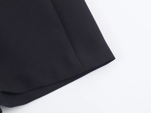 Vue détaillée de la texture du tissu noir tissé et des coutures de la jupe-culotte plissée