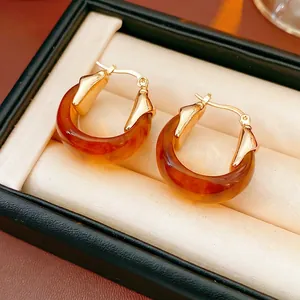 Boucles d'oreilles vintage en résine ambrée en forme de U sur boîte à bijoux
