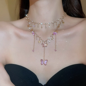 Detail of layered gold necklace with crystal butterfly pendants and shimmering rhinestones