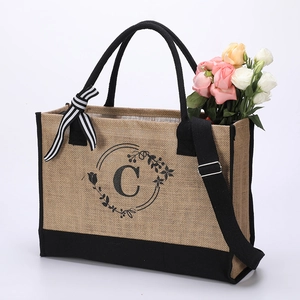 Rectangle jute tote bag with black handles and initial C monogram with floral wreath