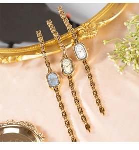 Detailed view of elegant vintage gold quartz watches with oval dials in white, cream, and blue