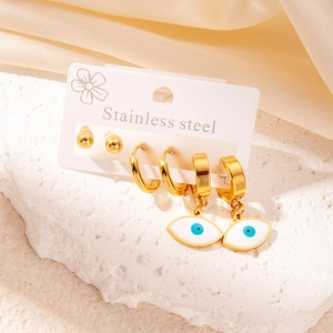 Detailed set of stainless steel evil eye hoop earrings and gold studs on a display card