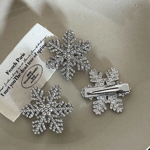Close-up of sparkling rhinestone snowflake hair clips with silver alloy duckbill structure