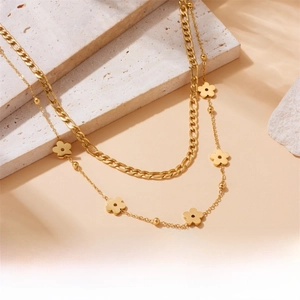 Detail view of multi-layered gold-plated stainless steel chains with a flower pendant
