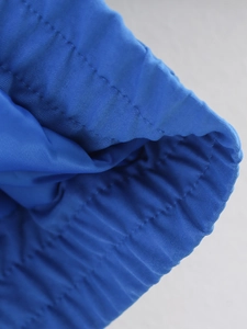 Close-up of bright blue quilted jacket showing elastic cuffs and detailed parallel stitching